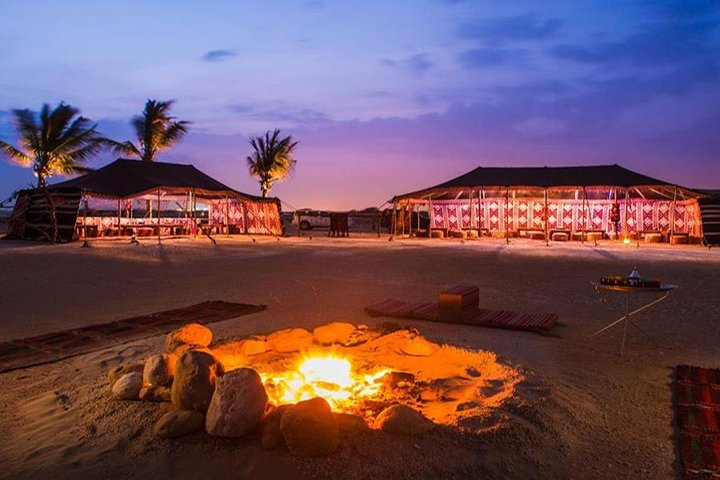 Immerse yourself in the serene beauty of the Arabian Desert where traditional Bedouin tents and a cozy campfire invite travelers to unwind savor local delicacies and enjoy enchanting cultural performances.